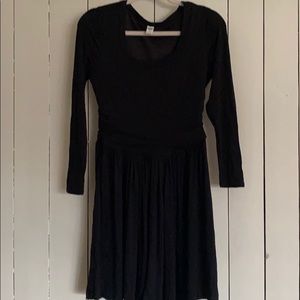 Black dress, cinched at the waist.